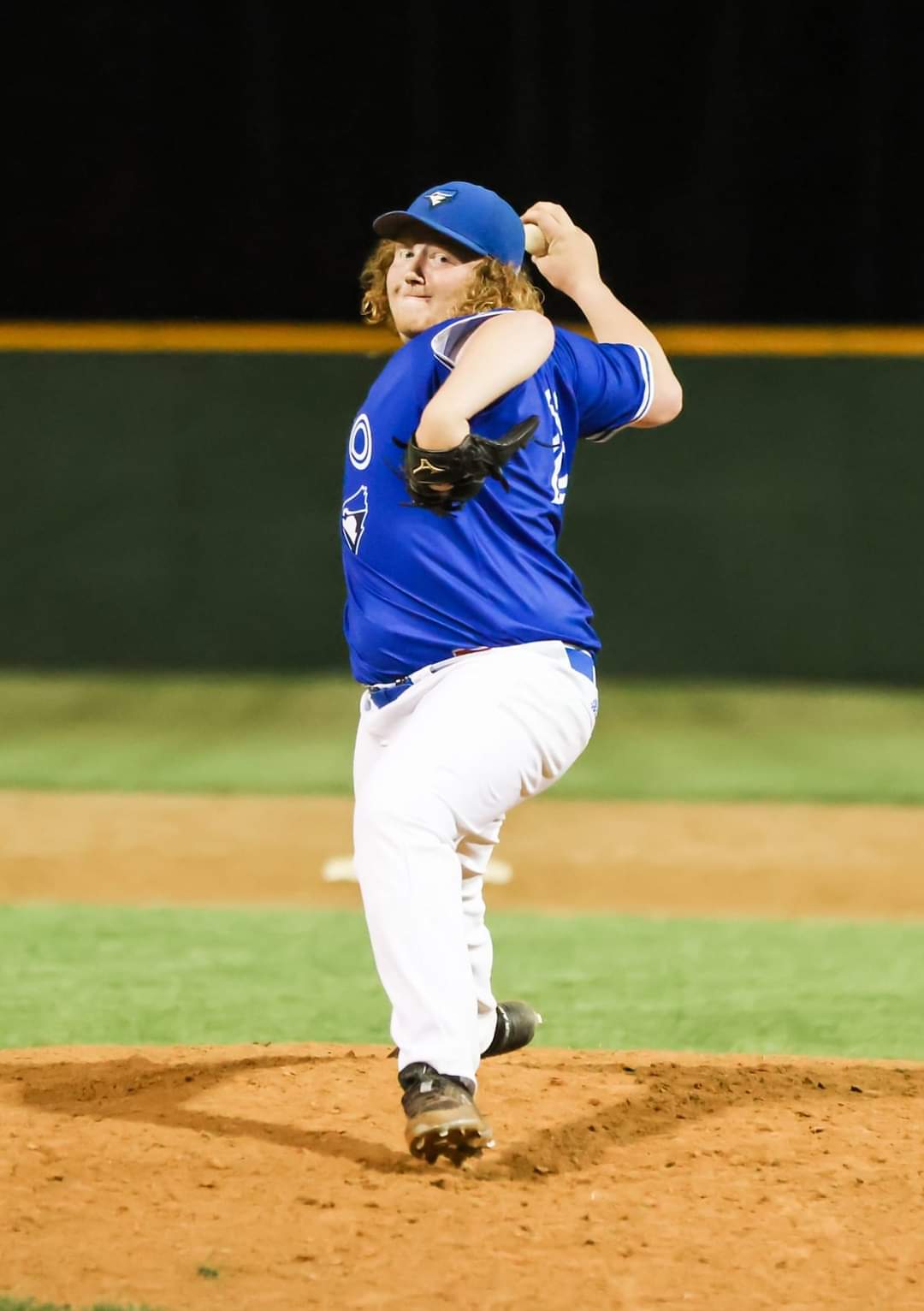 Drew Hedtke in his pitching wind-up under the lights