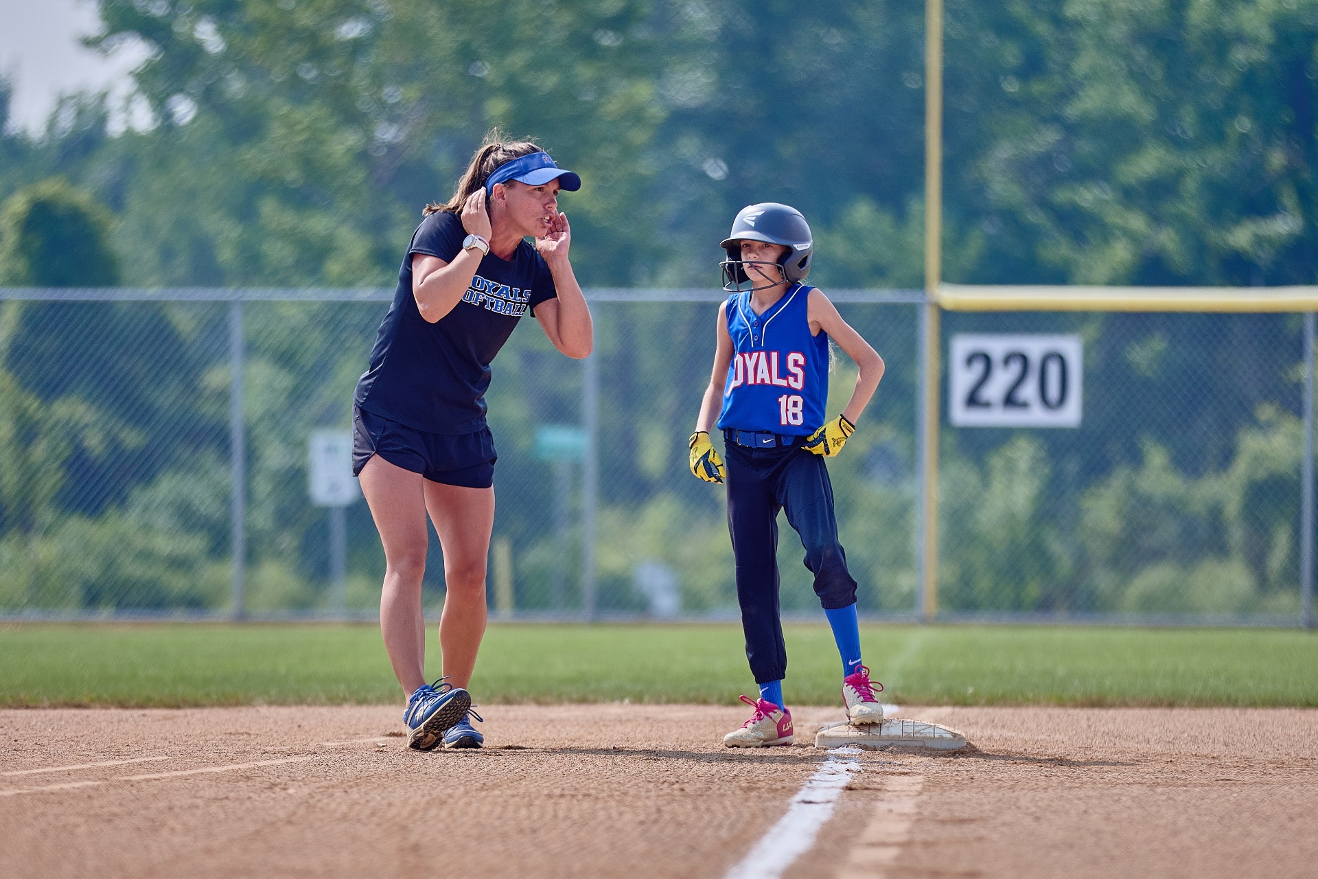 Bethany coaching a young Royals player on the base path