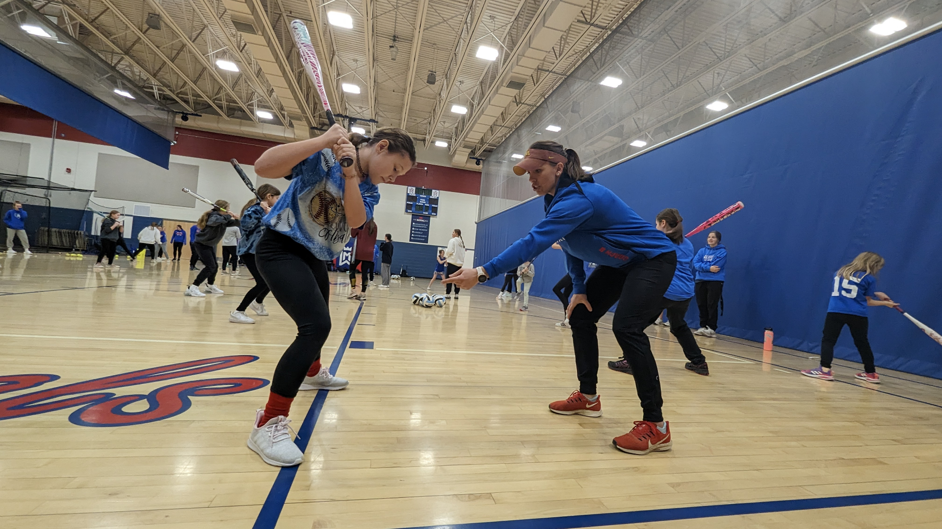 Bethany Loether coaching hitting mechanics at a softball clinic
